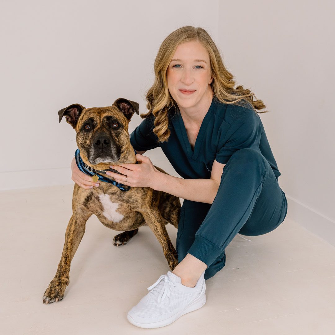 Alex And Gilly High Res female veterinarian sitting and posing with dog for a photo